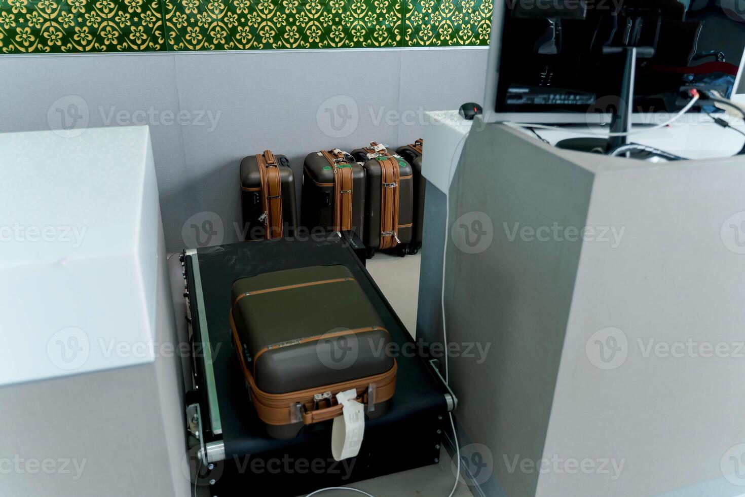 Suitcases lined up at baggage screening area in an airport security checkpoint, close-up view of luggage on conveyor belt in travel inspection zone photo
