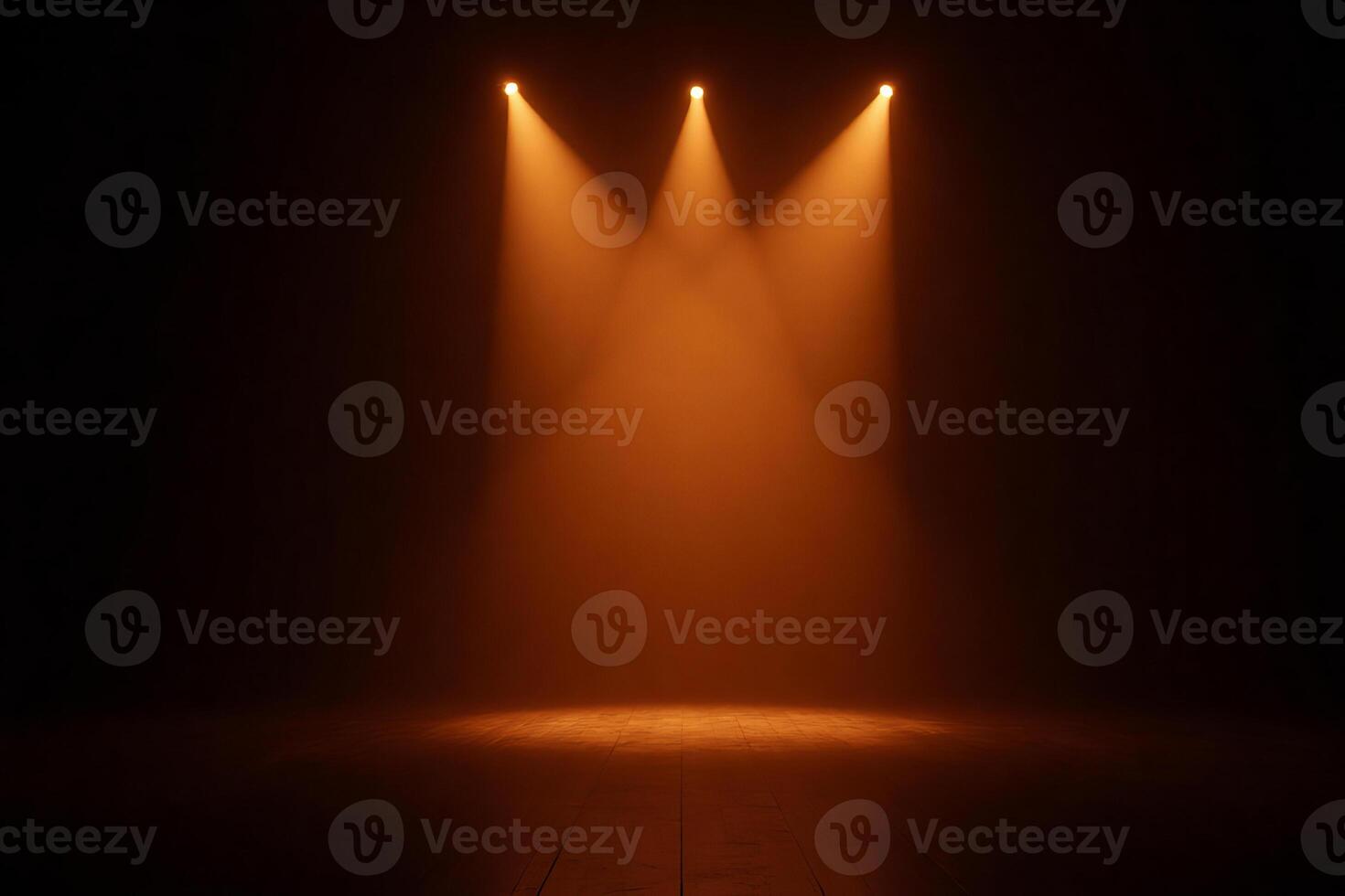 Three orange spotlights illuminating a dark stage, creating a dramatic effect with beams of light shining down, casting shadows and highlighting the texture of the floor photo