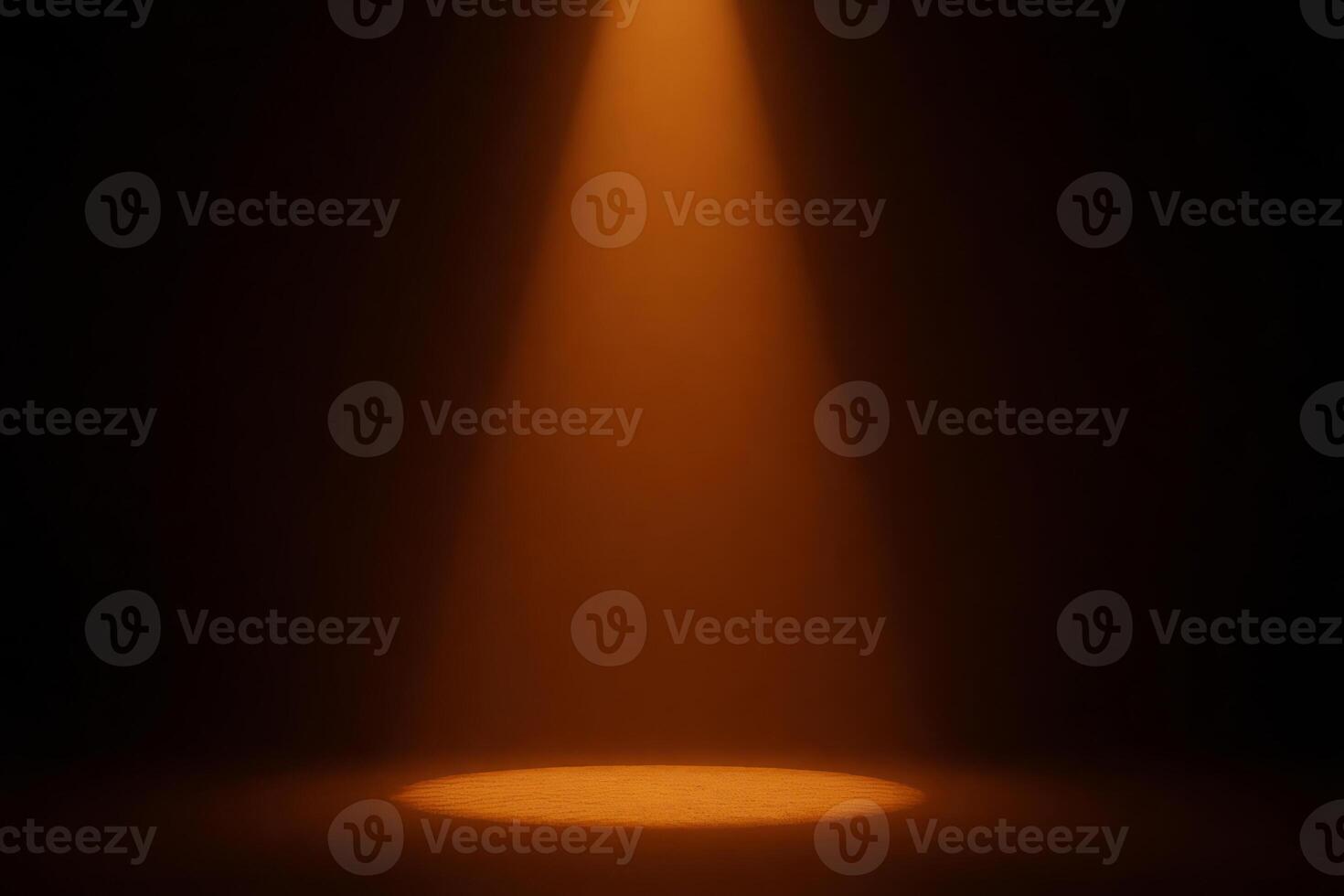 A beam of orange light shines down onto a circular spot on the ground, illuminating it brightly in a dark room photo