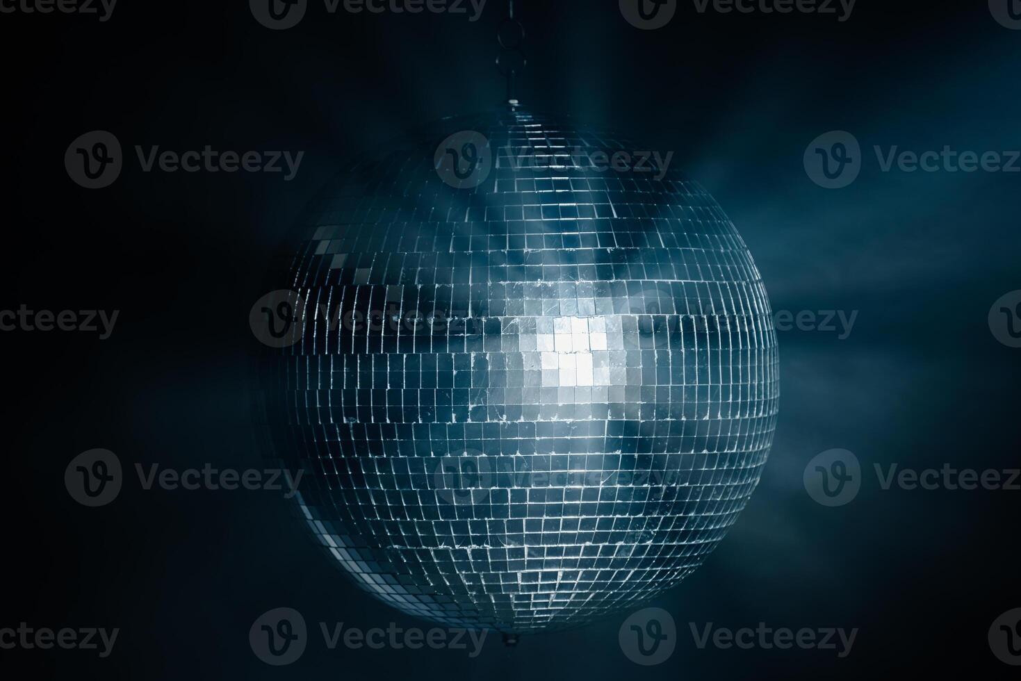 Disco ball reflecting dynamic rays of light against a black background. Perfect for creating a vibrant and energetic atmosphere at parties and events photo