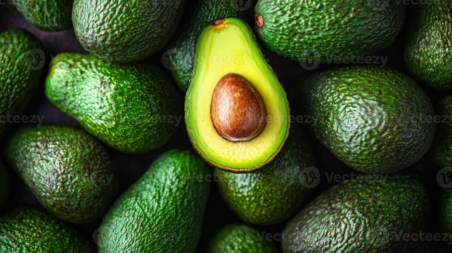 Close up View of Ripe Green Avocados With One Sliced in Half Showcasing Its Seed photo