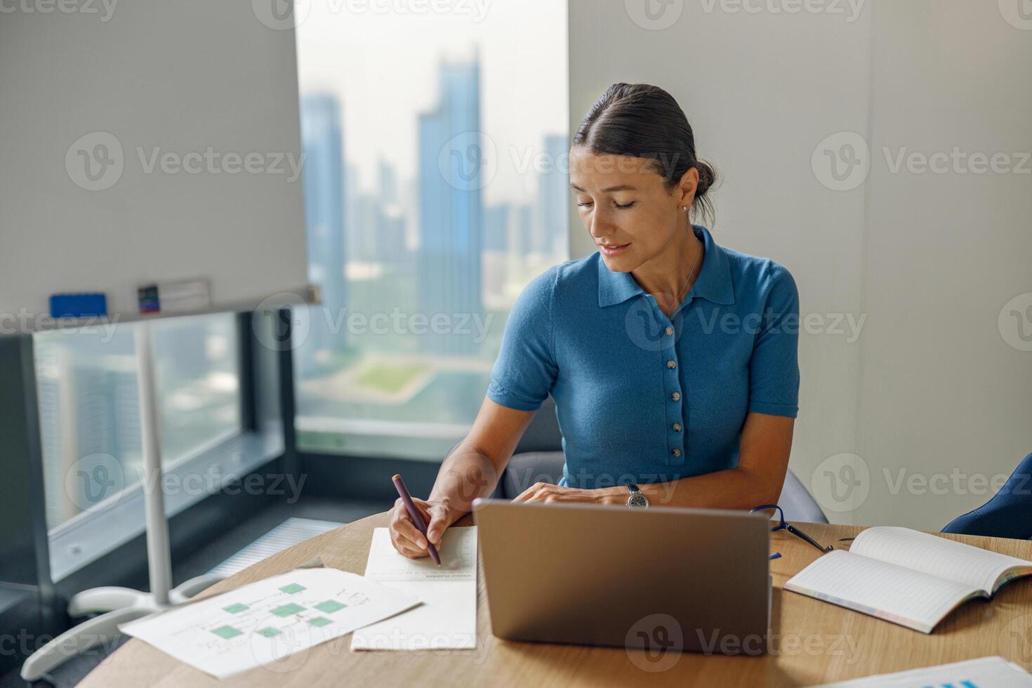 A dedicated business professional is diligently working on a laptop in a modern office space photo