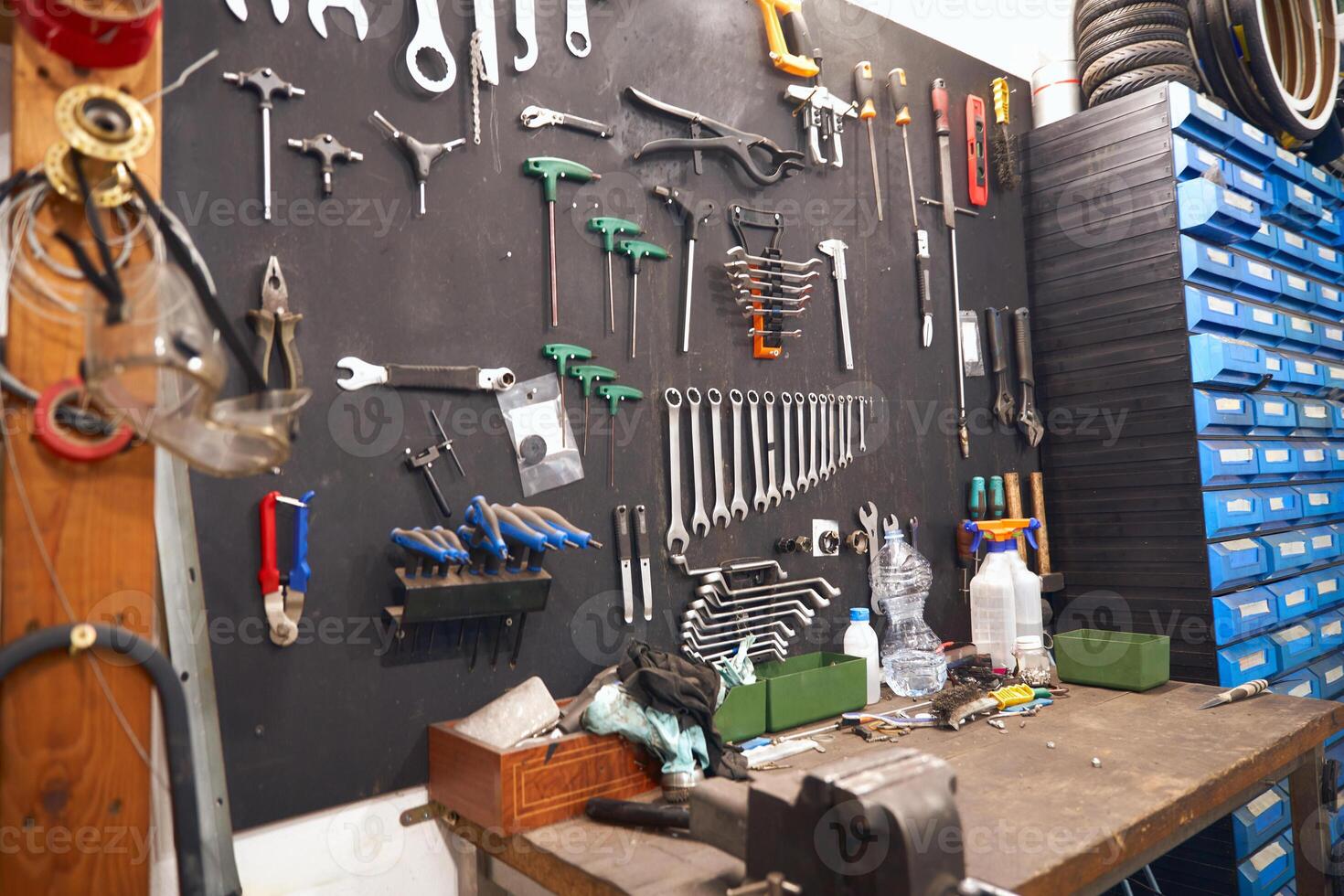 Stand with work tools in professional bicycle workshop photo