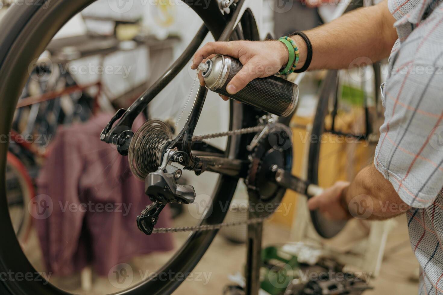 Close up of repairman is lubricate the bike chain in workshop. High quality photo