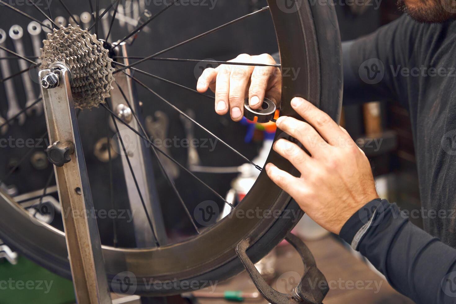 Close up of male mechanic working in bicycle workshop. Bike service, repair and upgrade photo