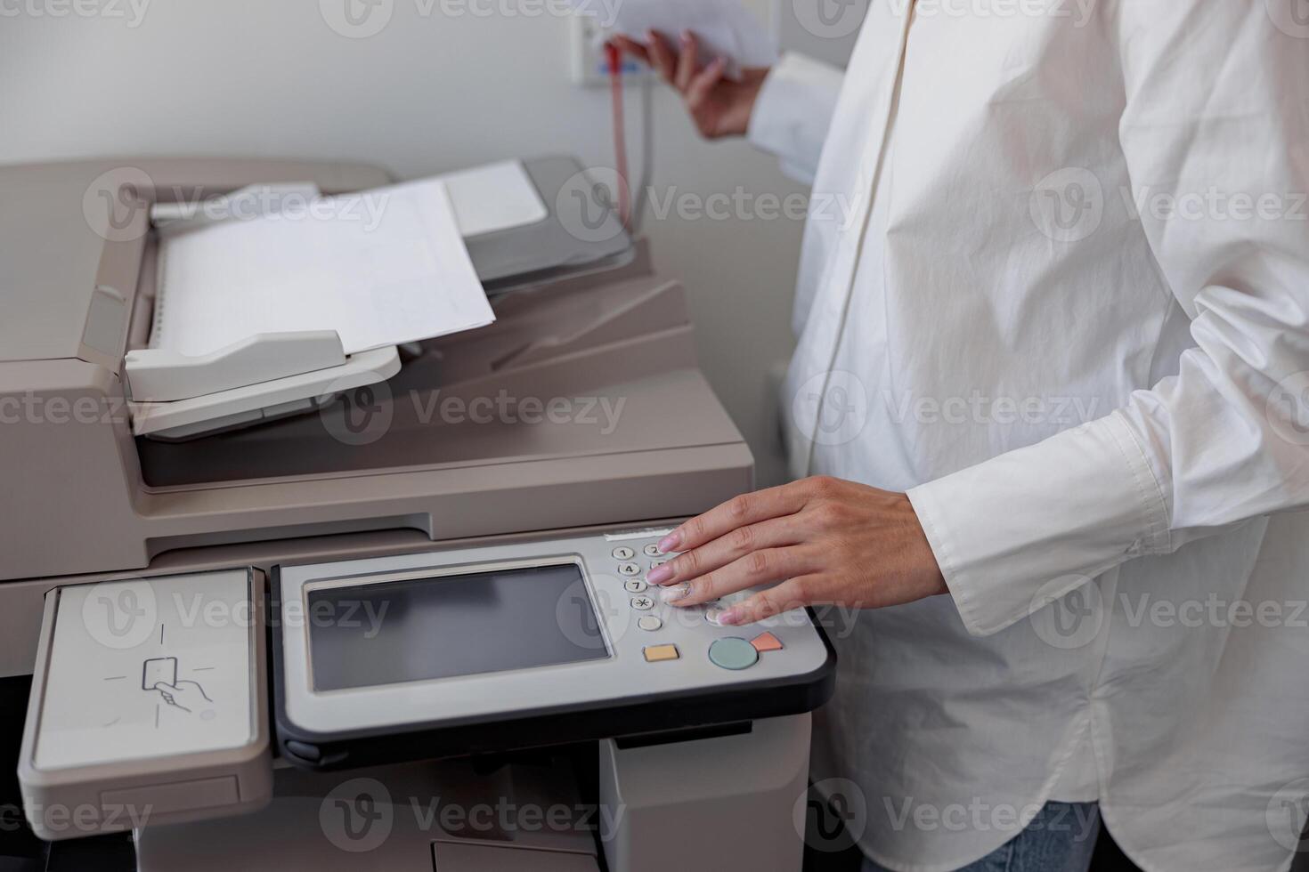 Close up of woman worker scanning a document on photocopy machine In modern office photo
