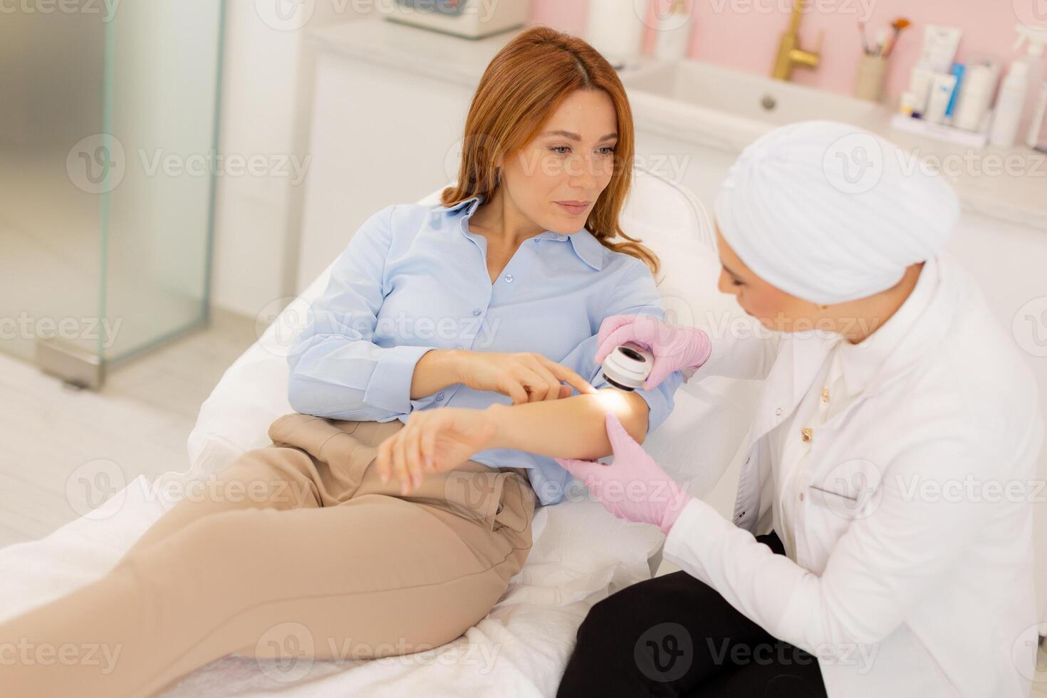 Woman receiving cosmetic treatment with dermatoscope from a skilled practitioner in a serene clinic environment photo