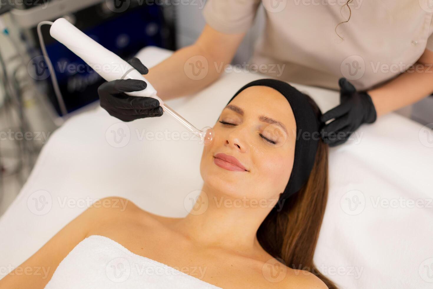 A woman getting a facial treatment with a machine photo