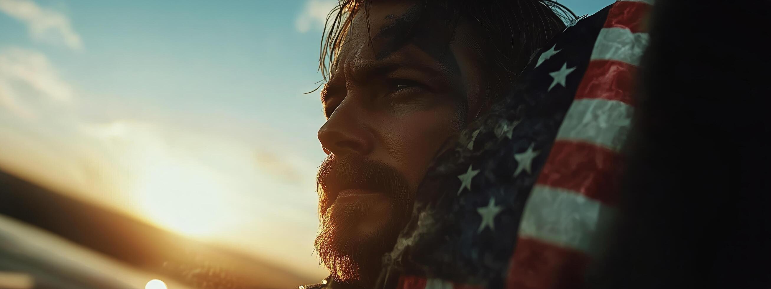 Courageous Soldier Gazes Into the Sunset While Wrapped in an American Flag by the Ocean photo
