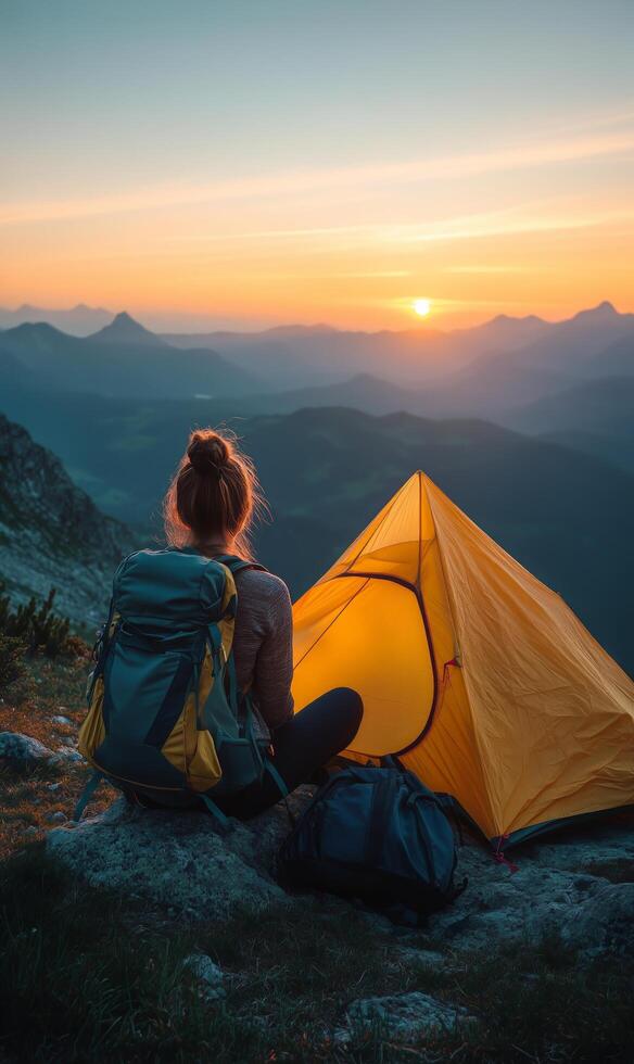 Setting up Camp at Sunset on a Mountain With a Vibrant Sky and a Cozy Tent photo
