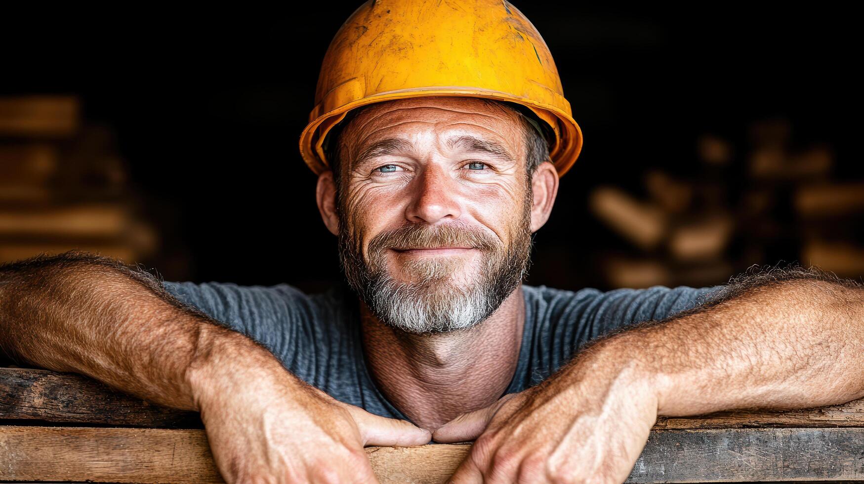 A man with a beard and a hard hat is leaning on a wooden plank photo