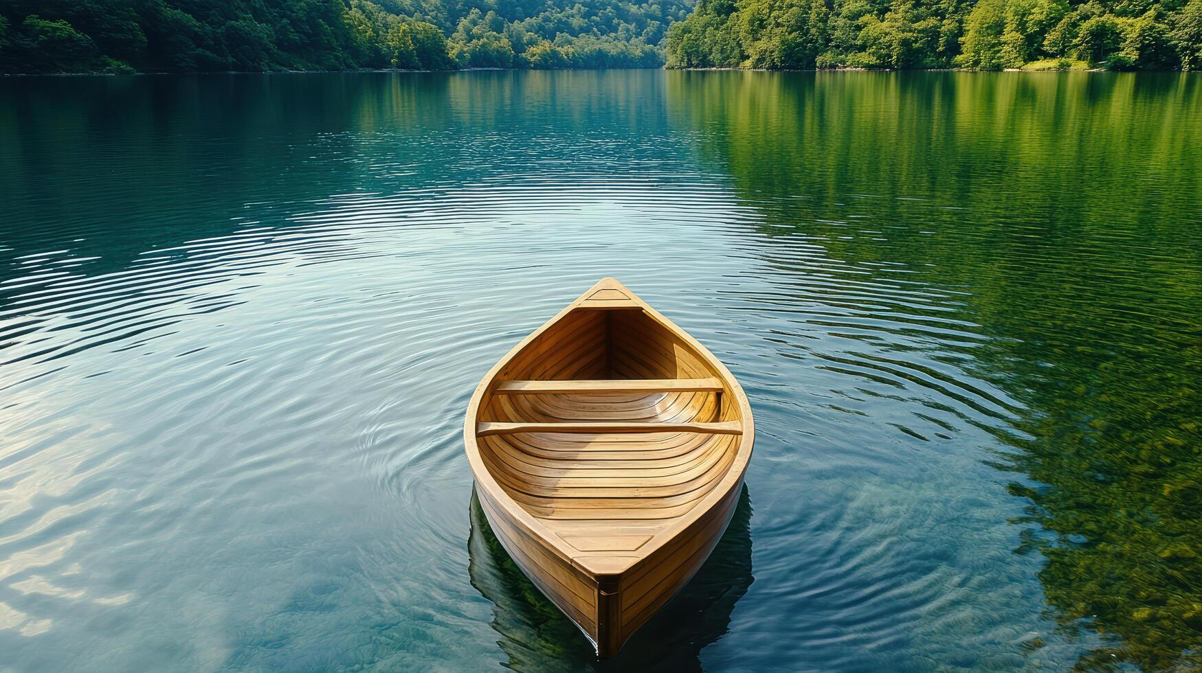 A wooden boat floating on the water in front of a forest photo