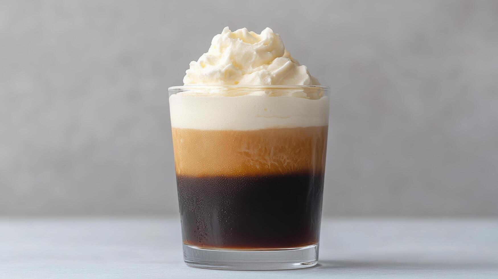 A tall glass of coffee with whipped cream photo