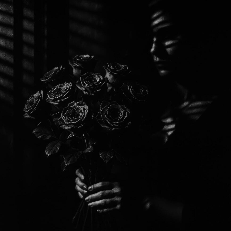 Dark Bouquet of Roses Held by a Figure in Shadowed Light With Striped Patterns on Skin photo