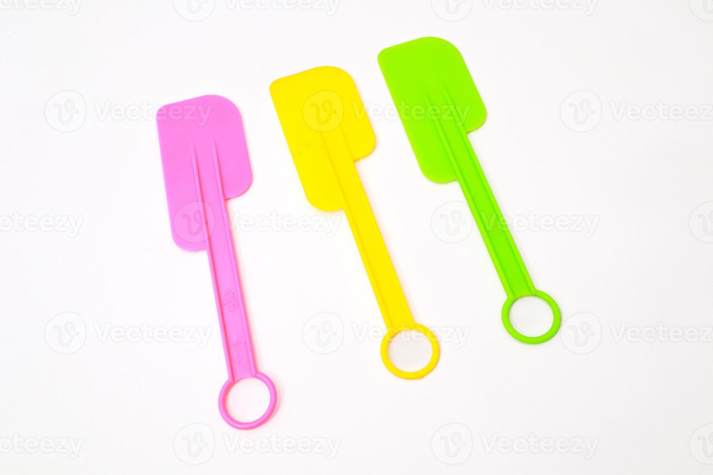 Colorful Plastic Spatulas Kitchen Utensils in Vivid Tones on White Backdrop photo