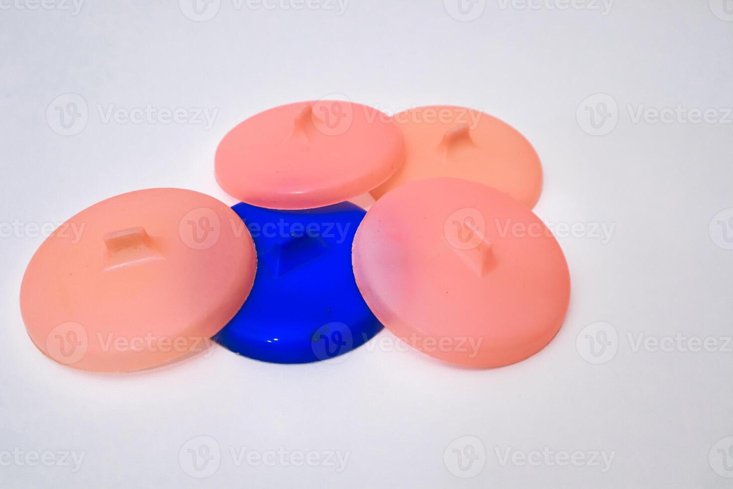 Round Plastic Lids in Varied Colors Arranged Against Bright White Backdrop photo