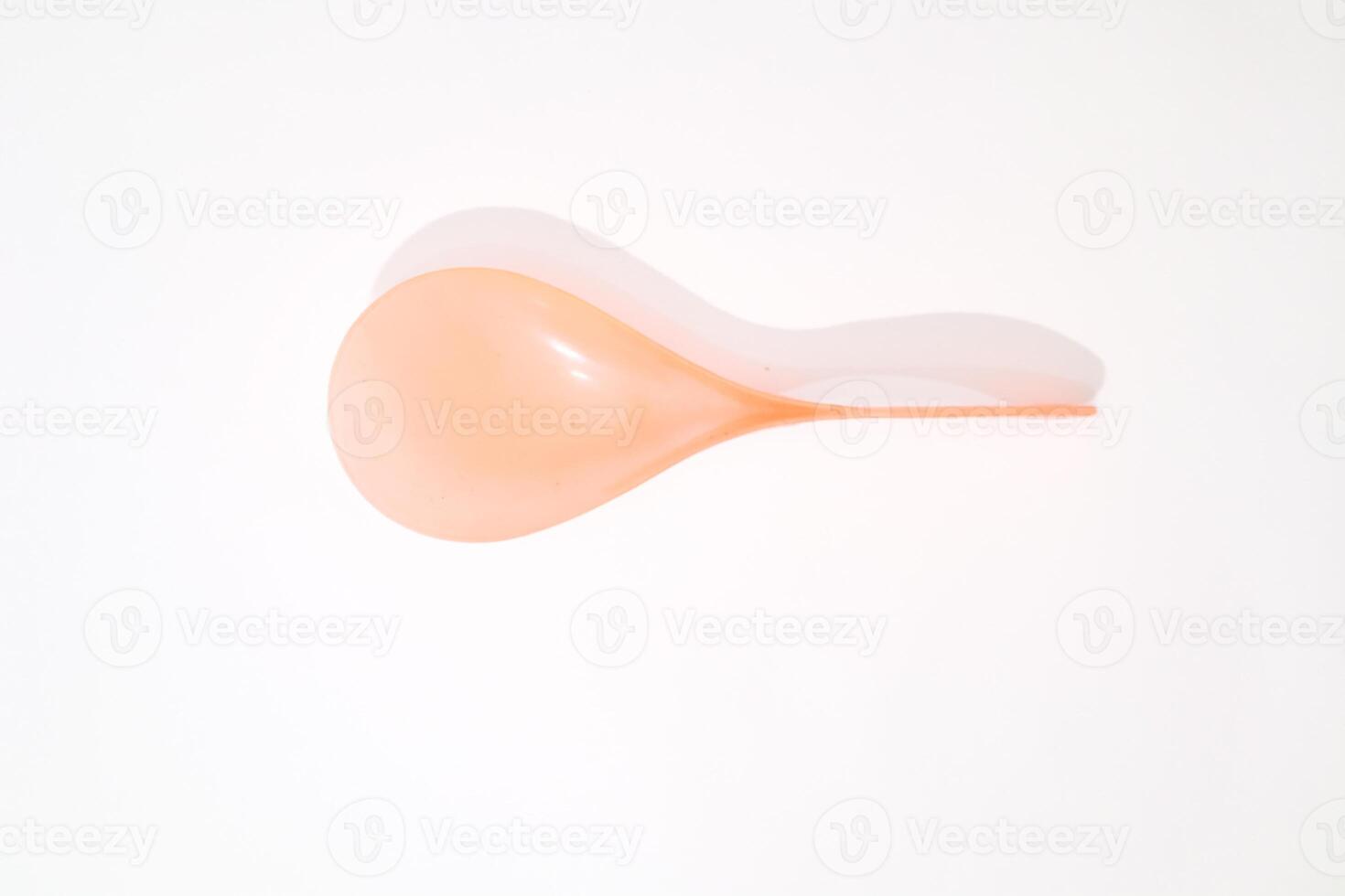 Minimalist image of an orange balloon with its shadow on a white backdrop photo