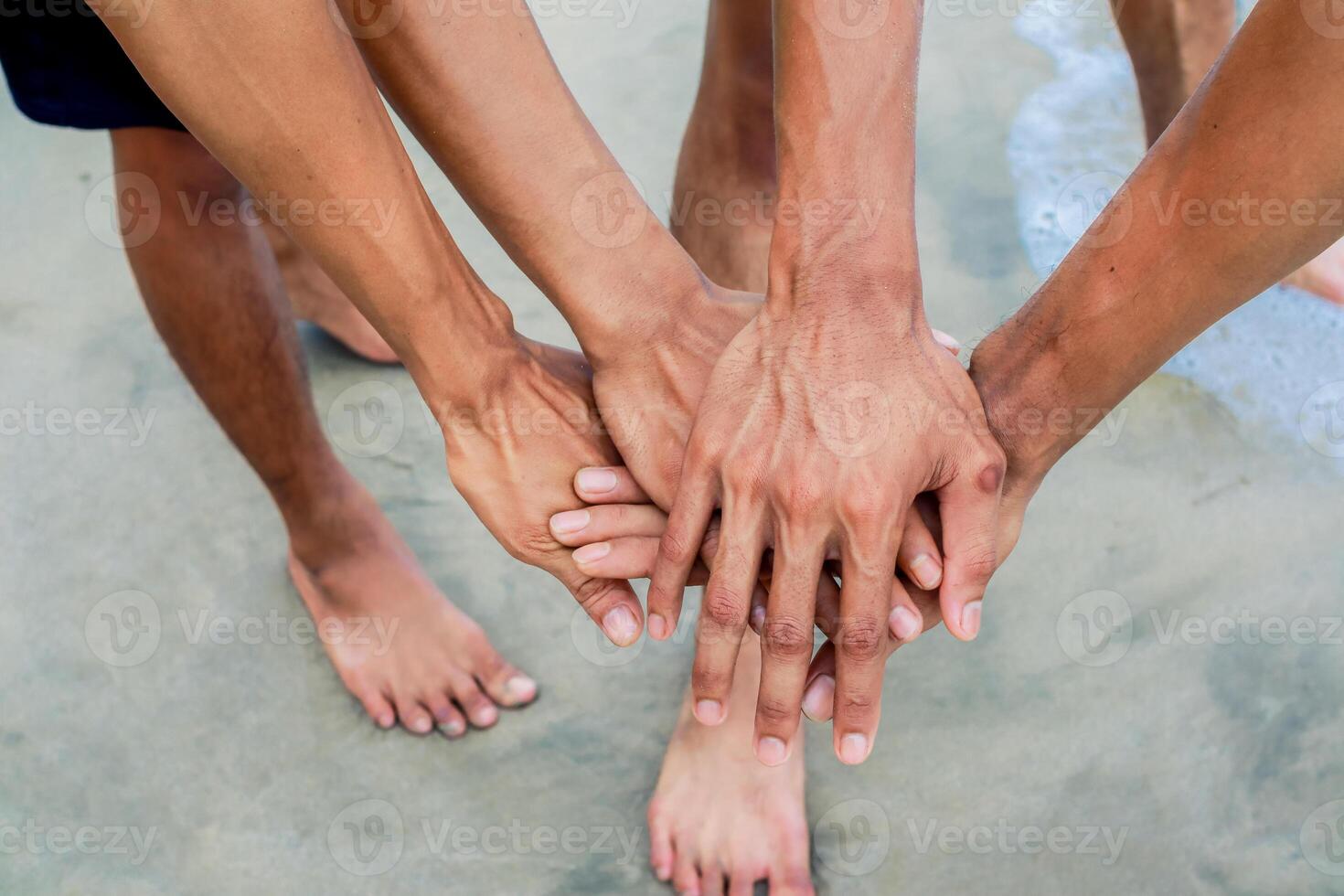 United Hands on Sandy Beach Symbolizing Group Cohesion and Collaboration photo