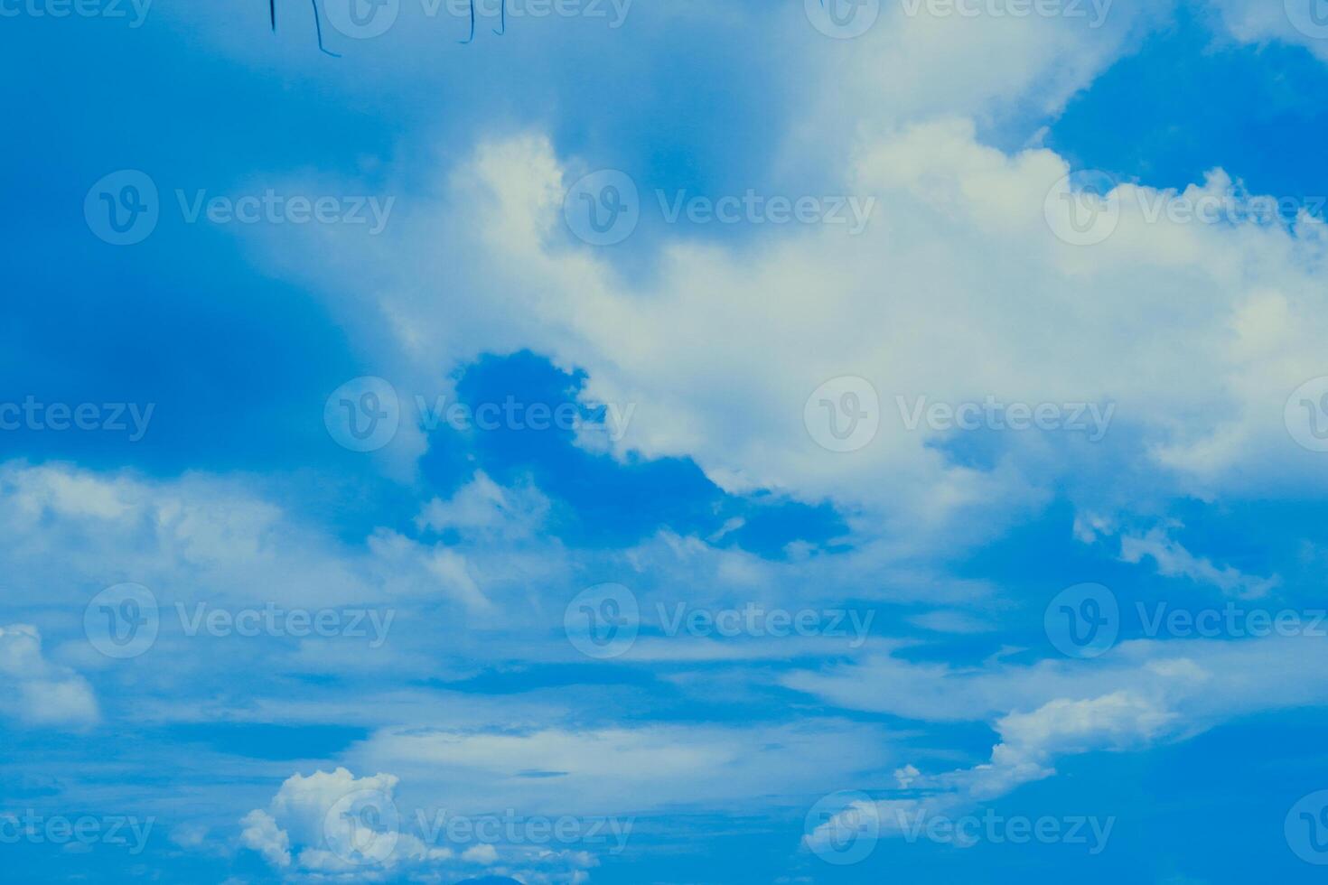 Serene blue sky filled with fluffy, ethereal clouds and tranquil atmosphere photo