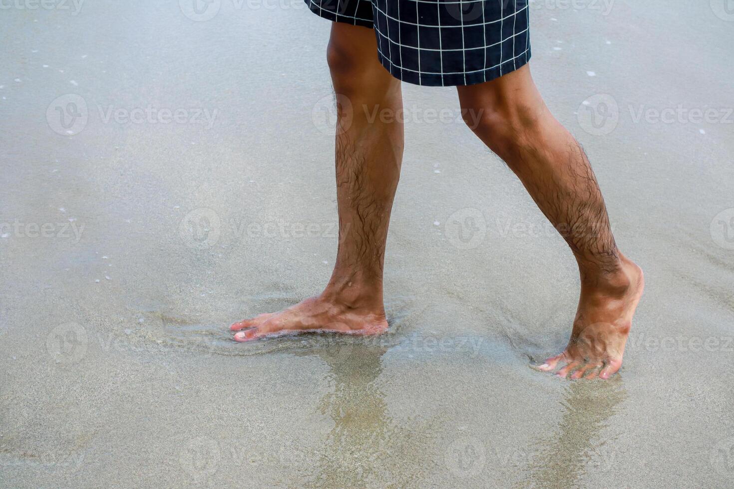 Man strolling along sandy beach enjoying waves and freedom in swimwear photo