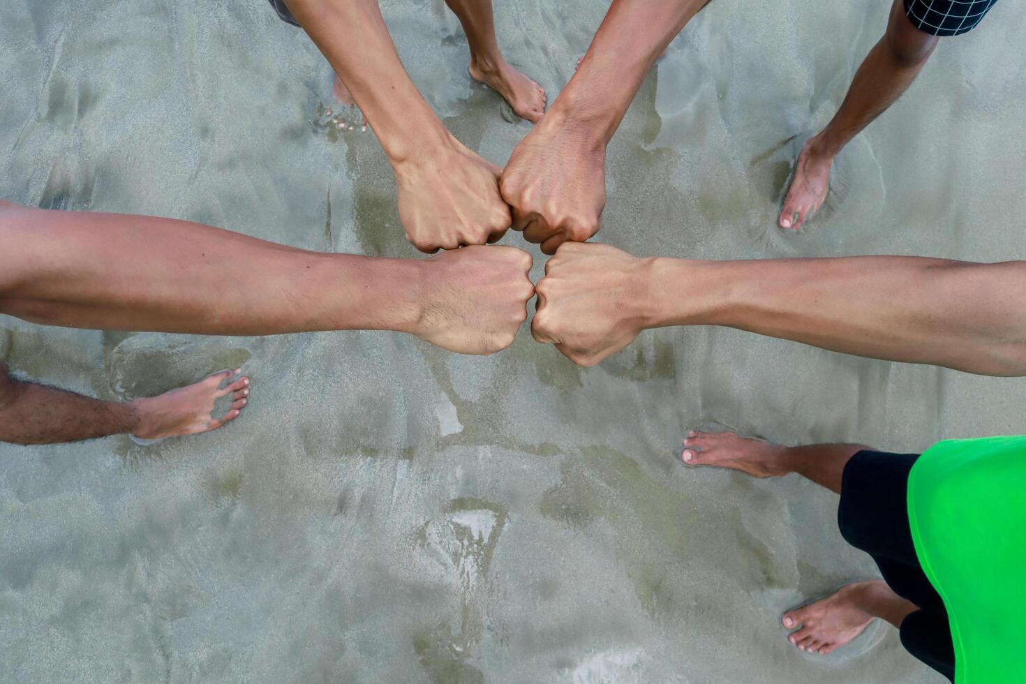 fists bump on beach, symbolizing a group achievement photo
