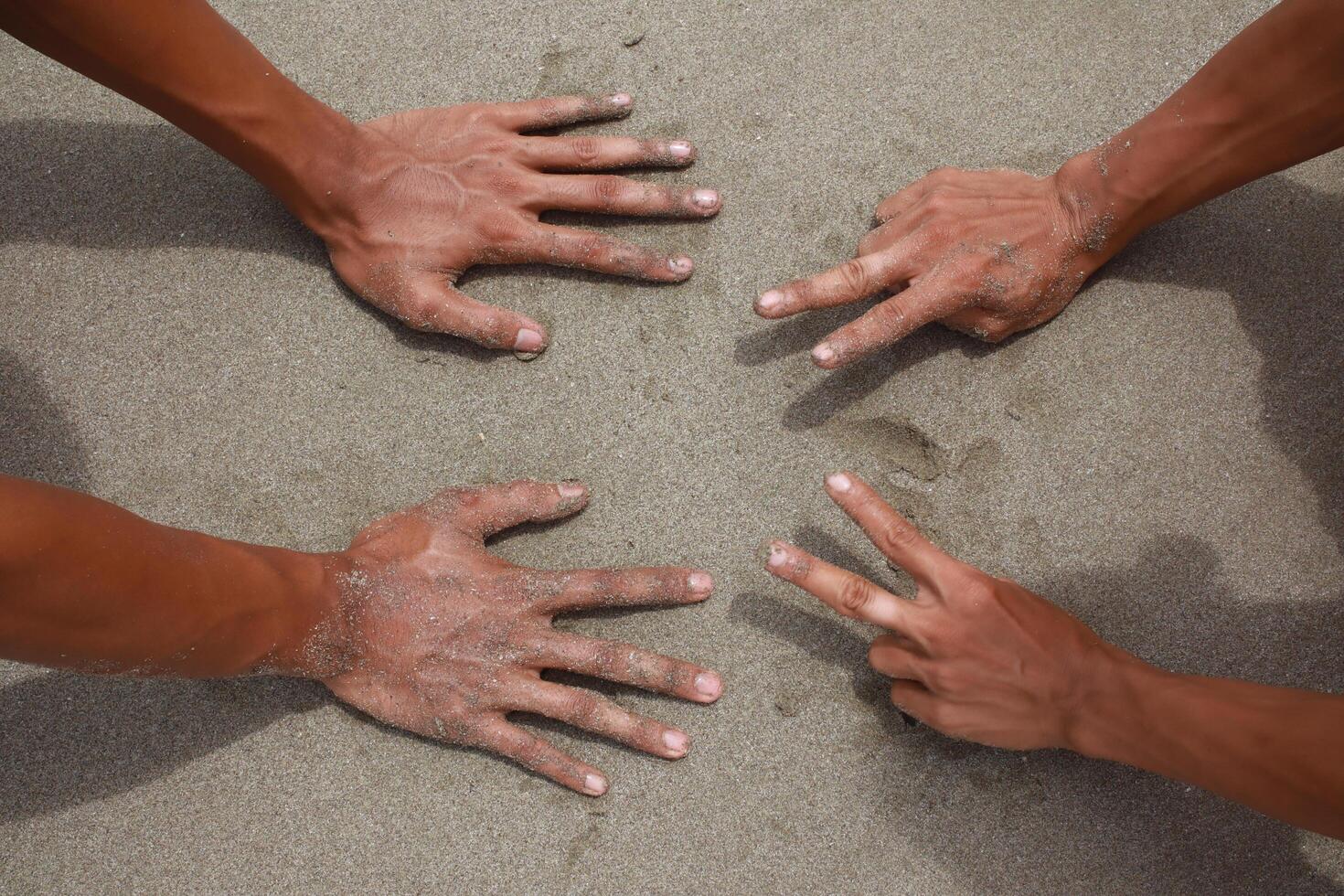 Two Pairs of Hands Forming Rock, Paper, Scissors Gestures photo