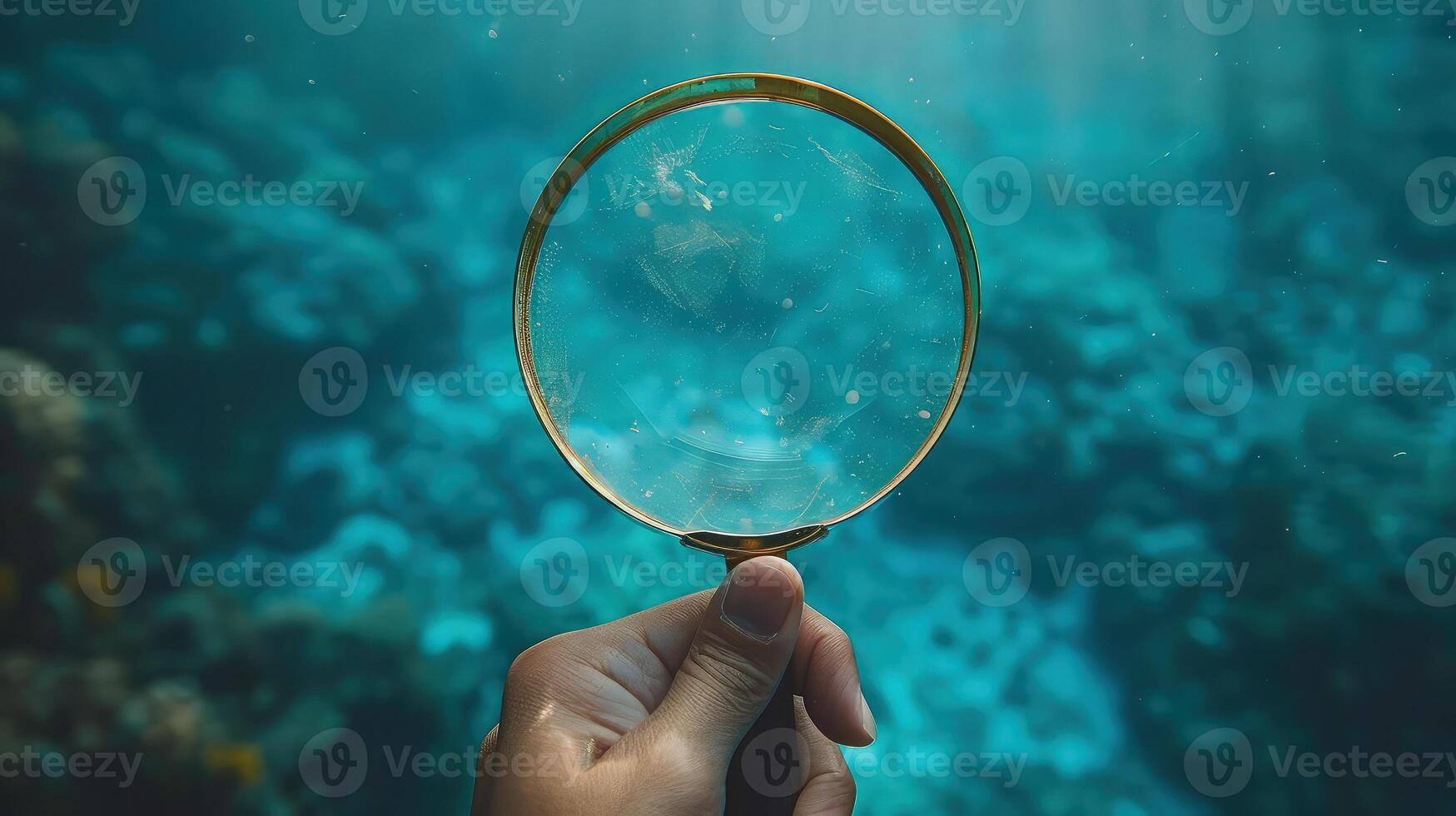 A person holding a magnifying glass over an underwater scene photo