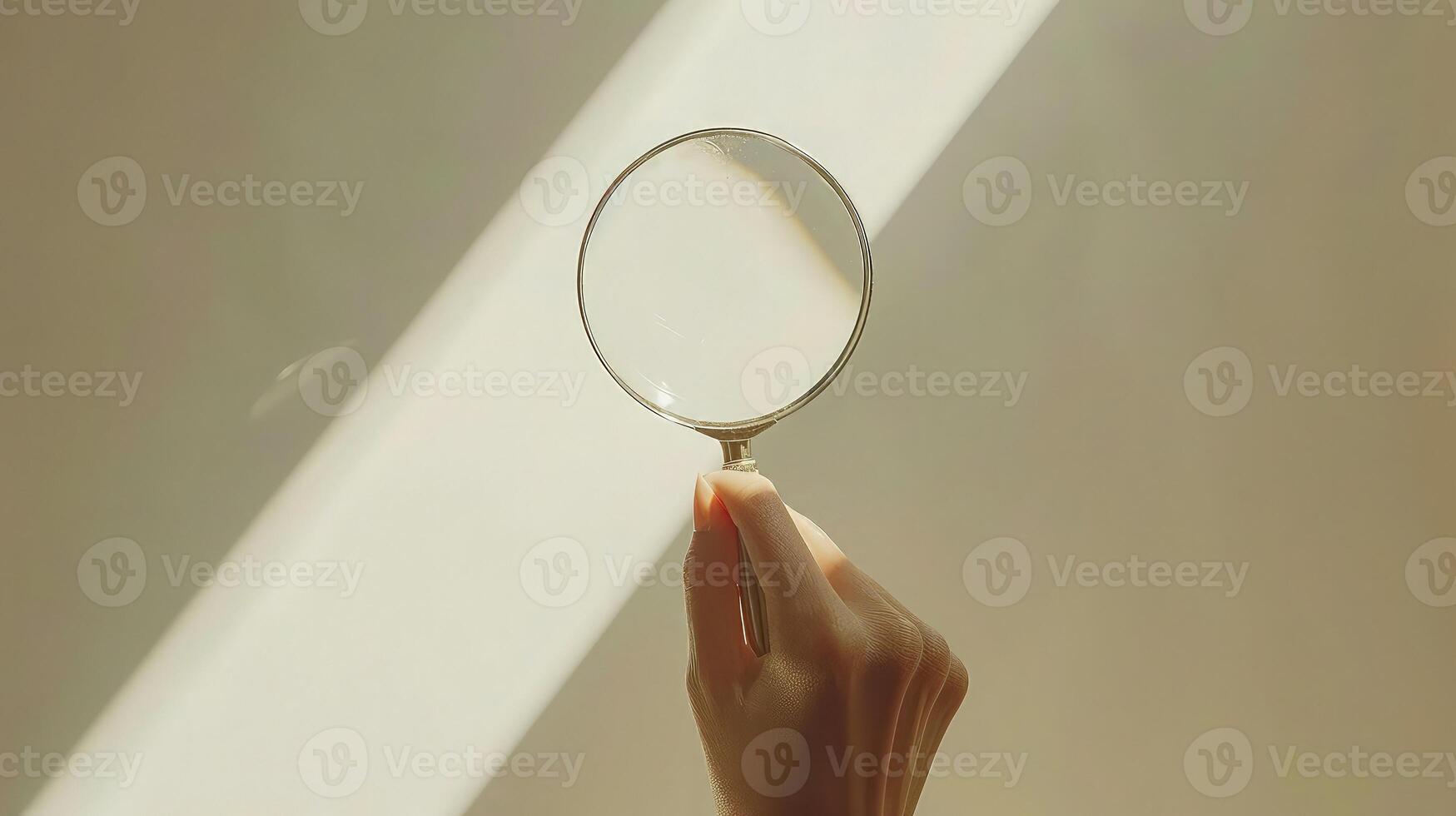 A person holding a magnifying glass over a white surface photo