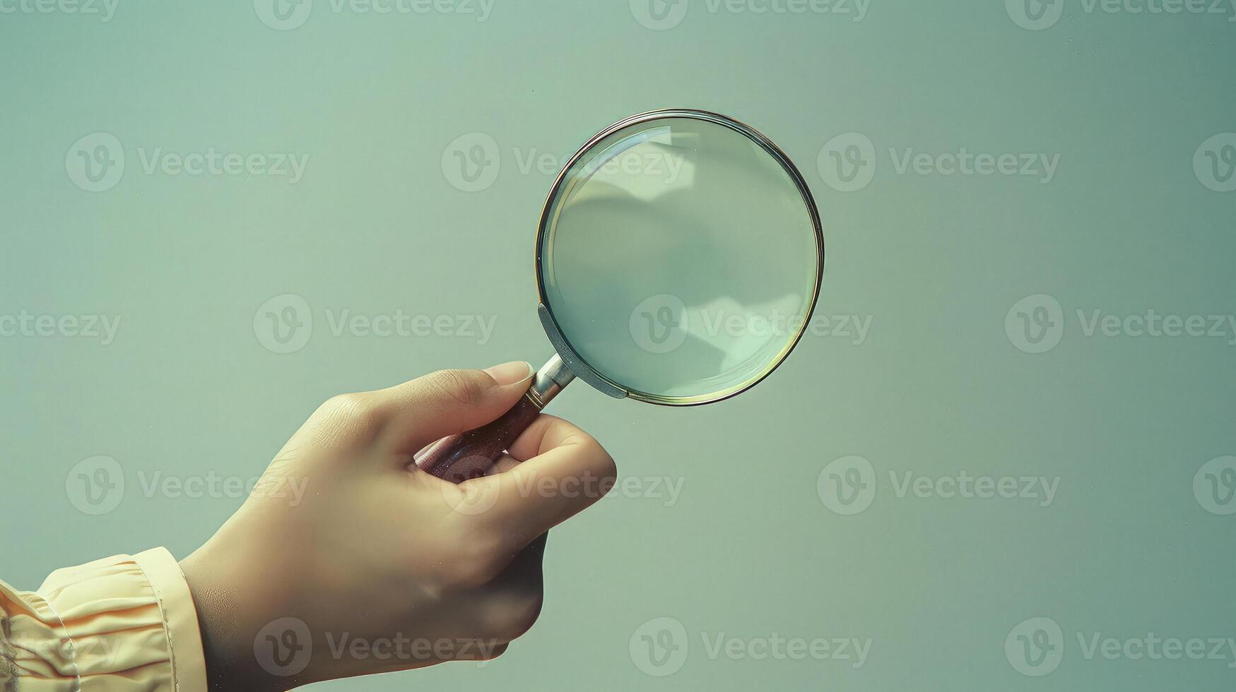 A person holding a magnifying glass over a surface photo