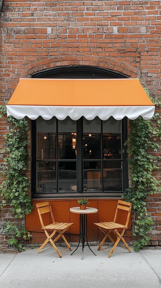 A table and chairs under an orange awning photo