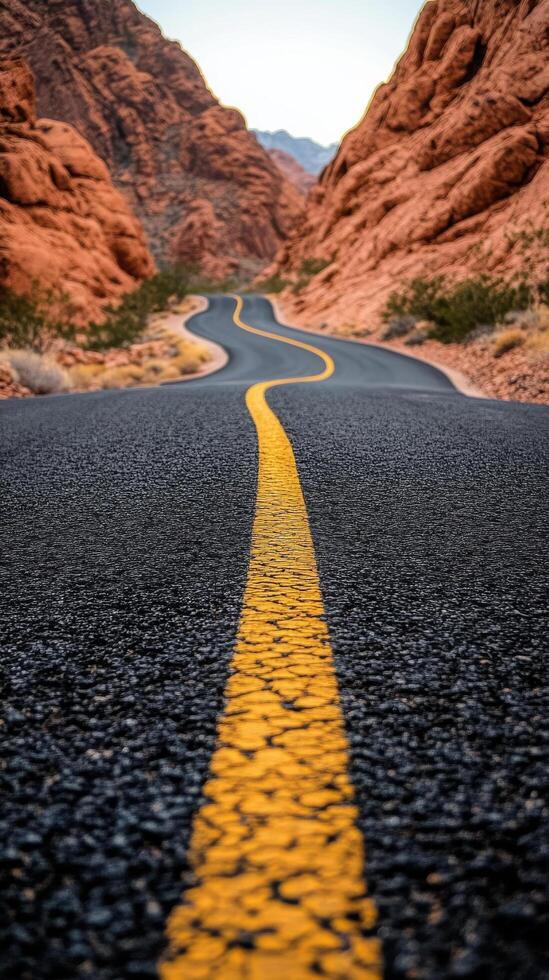 A long road with yellow lines in the middle of the desert photo