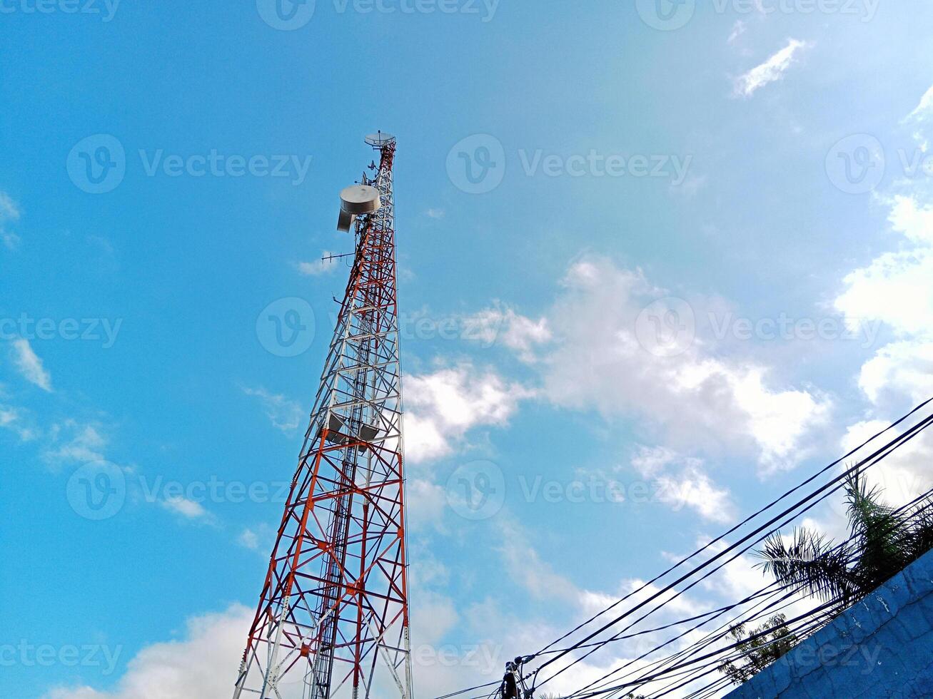 Wide angle view of telecommunication tower with cloudy sky background on a sunny day photo