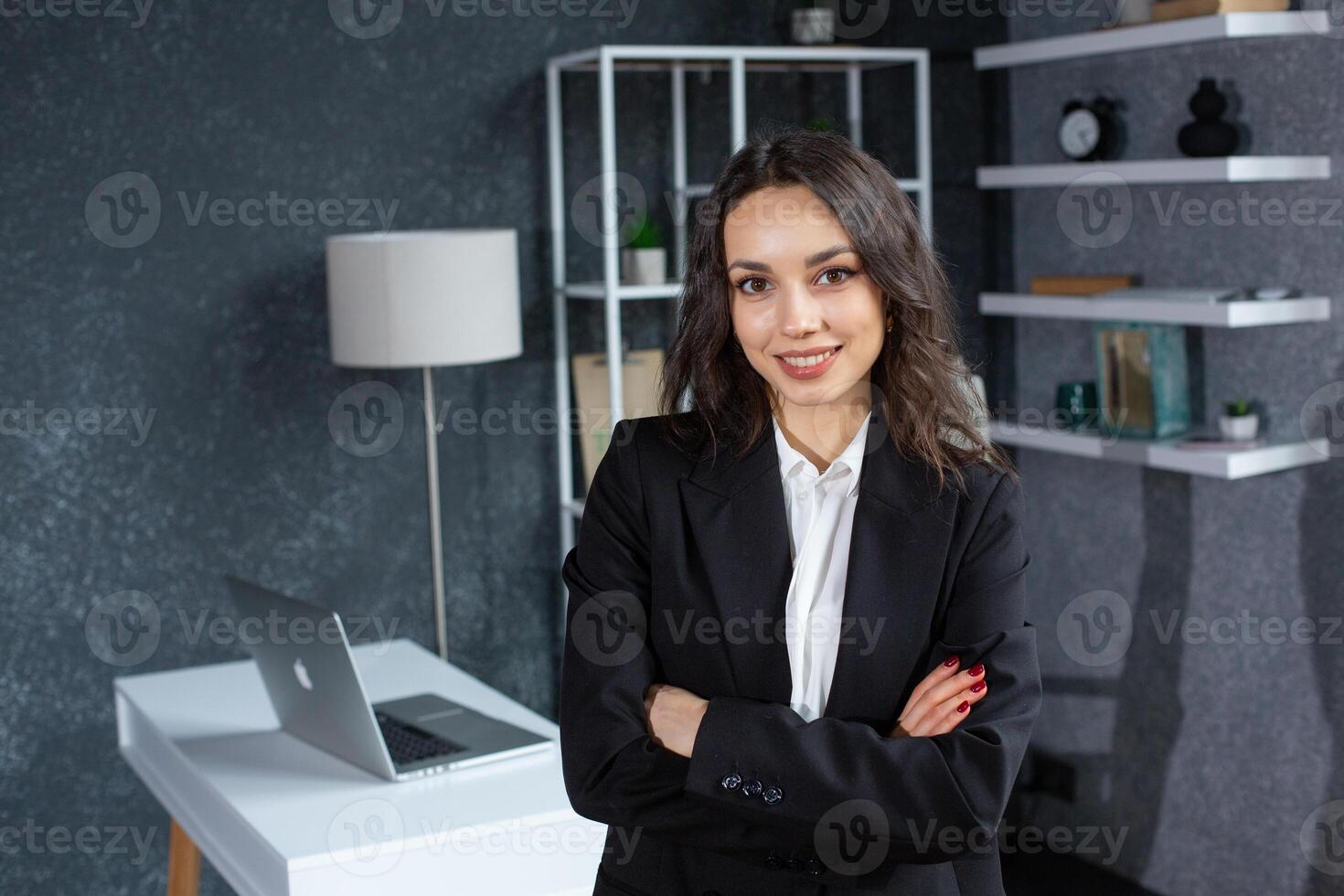 portrait of smiling businesswoman with crossed arms looking at camera in office. photo