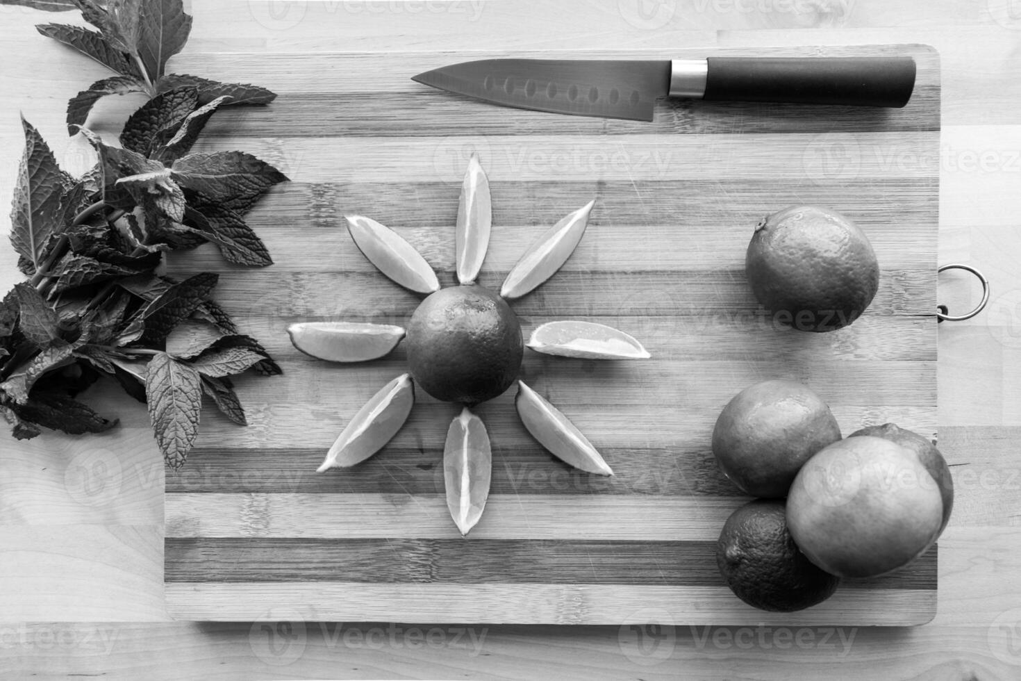 a black and white image of sliced limes on a chopping board photo