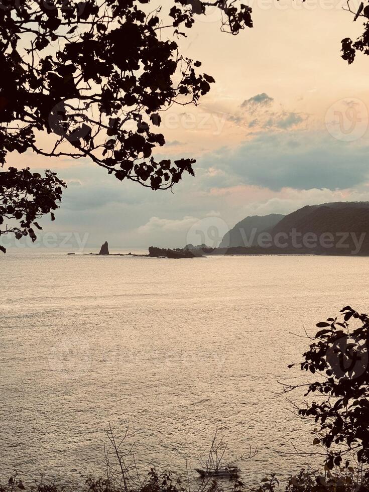Sunset Over Rocky Coastal Cliffs. Payangan Beach Jember, Indonesia photo