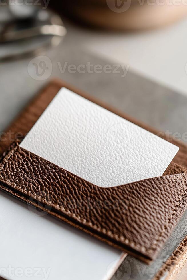 Soft lighting highlights a blank business card partly tucked into a high-quality leather cardholder, set against a blurred executive workspace background. This image exudes professionalism photo