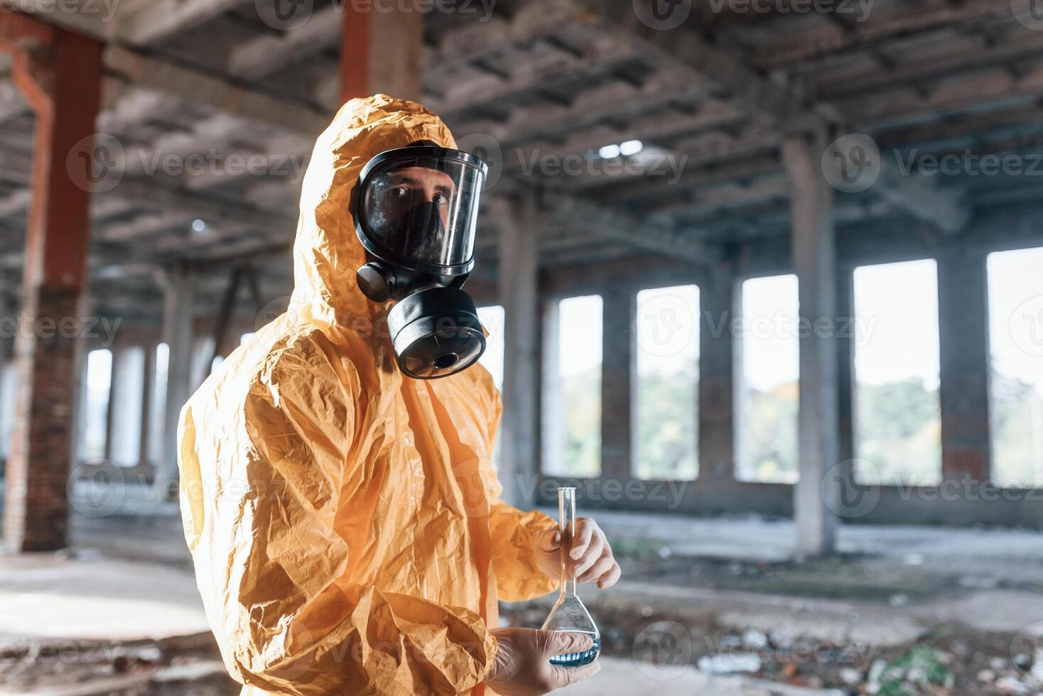 Portrait, of man ,dressed in chemical protection suit that is in the ruins of the post apocalyptic building photo