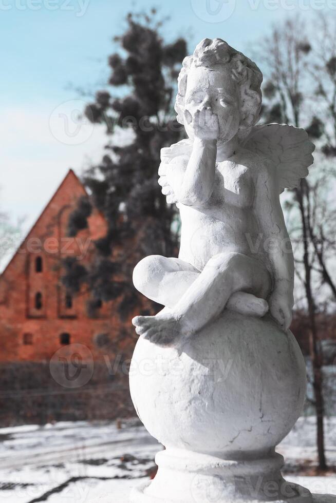 Bargationovsk Kaliningrad region Russia February 21 2021 Angel sculpture against the backdrop of Forburg Castle Preussisch-Eylau photo