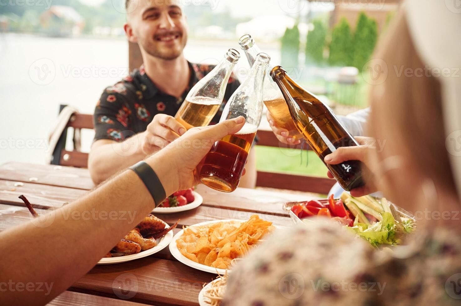 Doing cheers.. Group of people are with beer in hands having good time photo