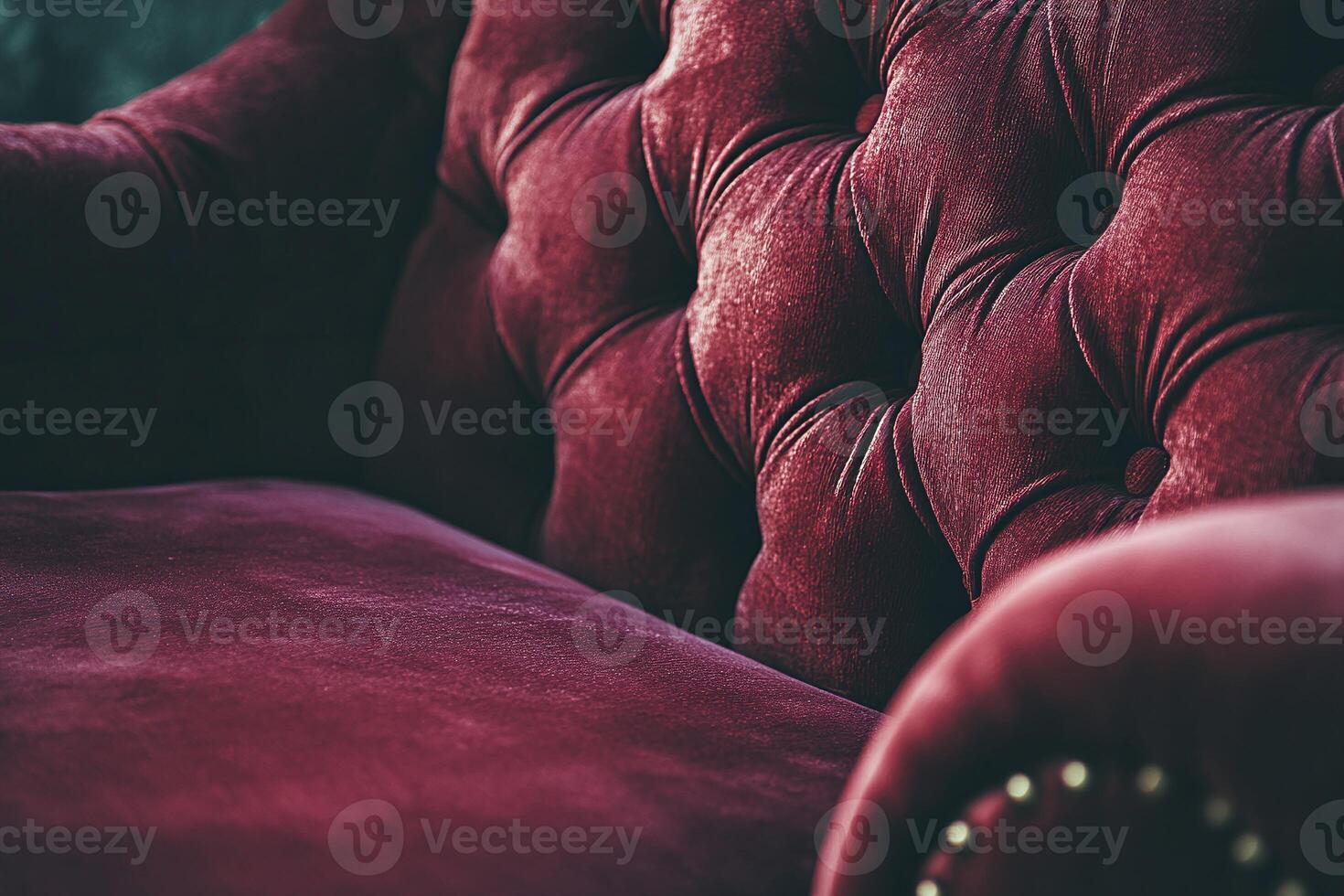 Closeup of Luxurious Burgundy Velvet Tufted Armchair with Brass Accents in Dramatic Lighting photo