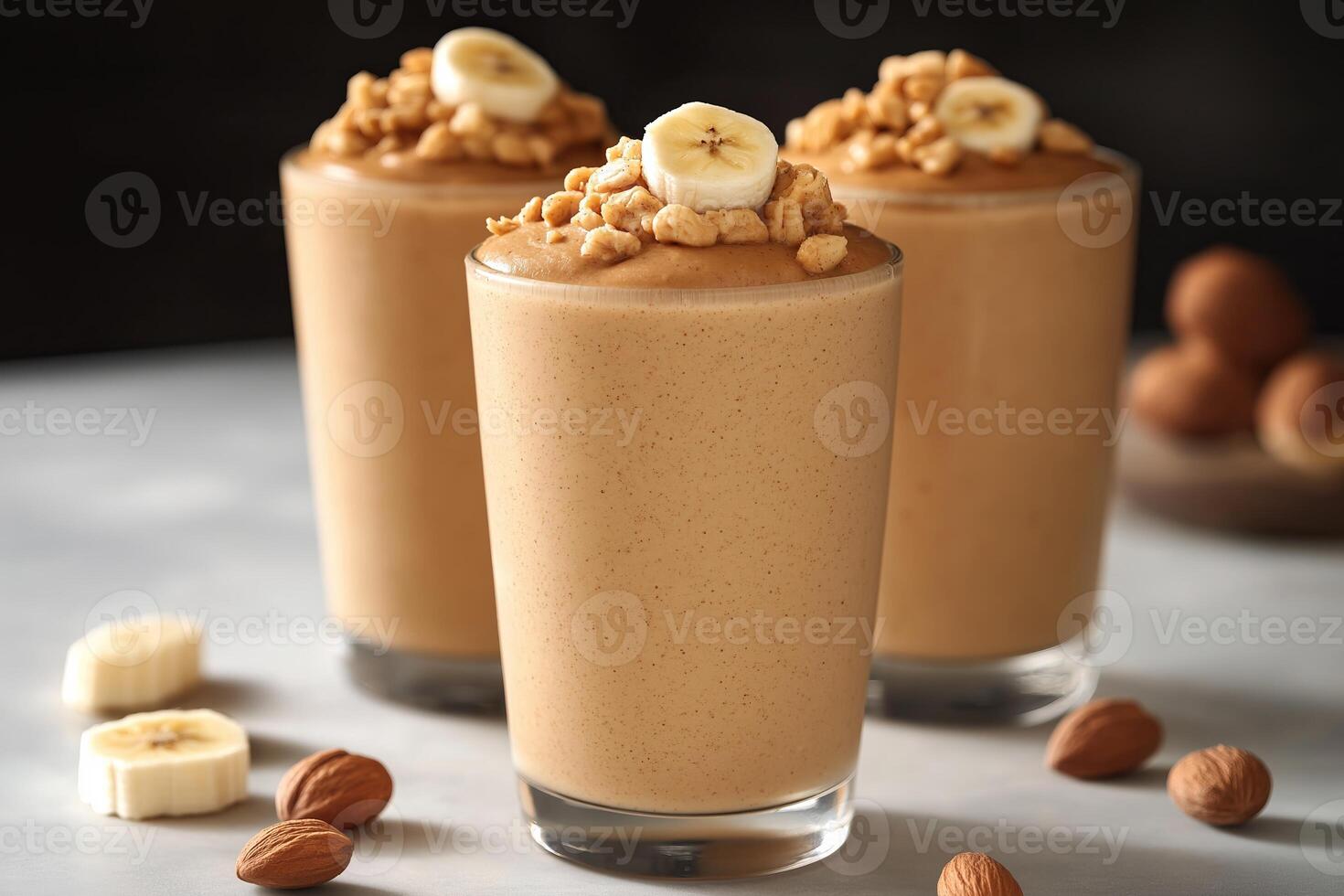 Deliciously creamy banana peanut butter smoothies topped with crunchy nuts in a cozy kitchen setting. Three tall glasses of smooth banana smoothies are garnished with sliced bananas and nuts photo