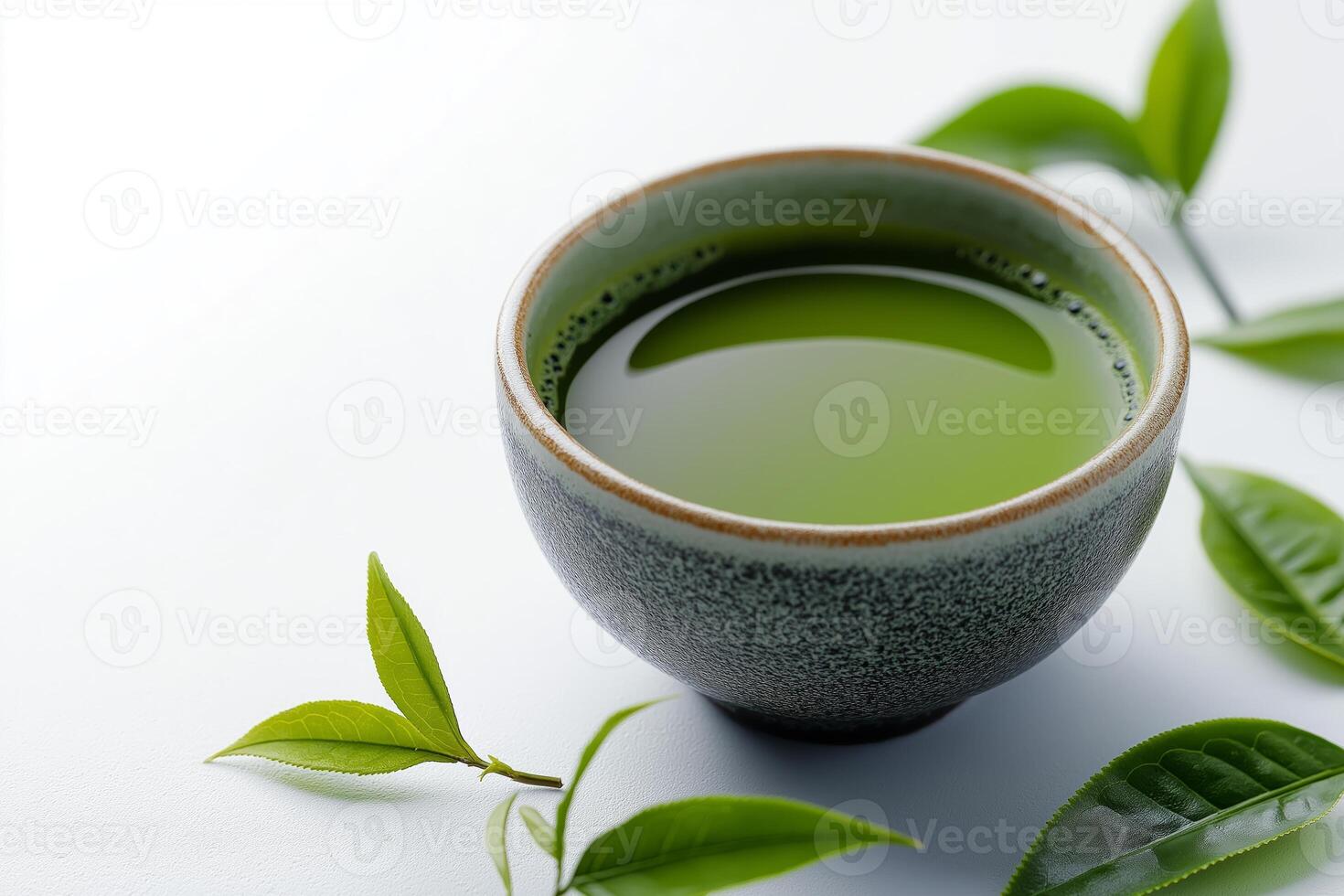 Discovering the vibrant elegance of matcha tea in a traditional bowl surrounded by fresh green leaves. rustic bowl filled with rich green matcha tea on smooth surface, accompanied by fresh tea leaves photo
