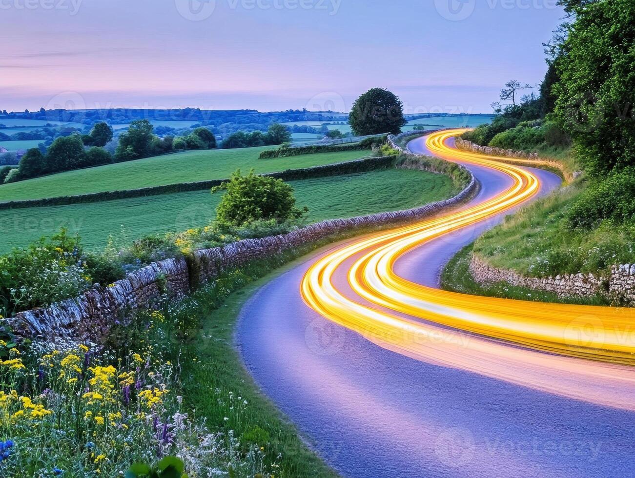 Winding country road with light trails at twilight in rural landscape photo