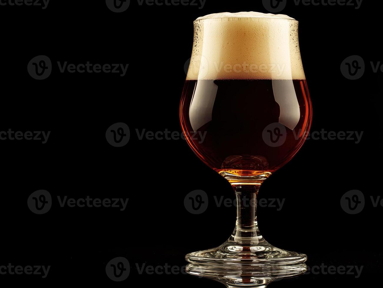 Craft beer in a glass with a frothy head against a dark background photo