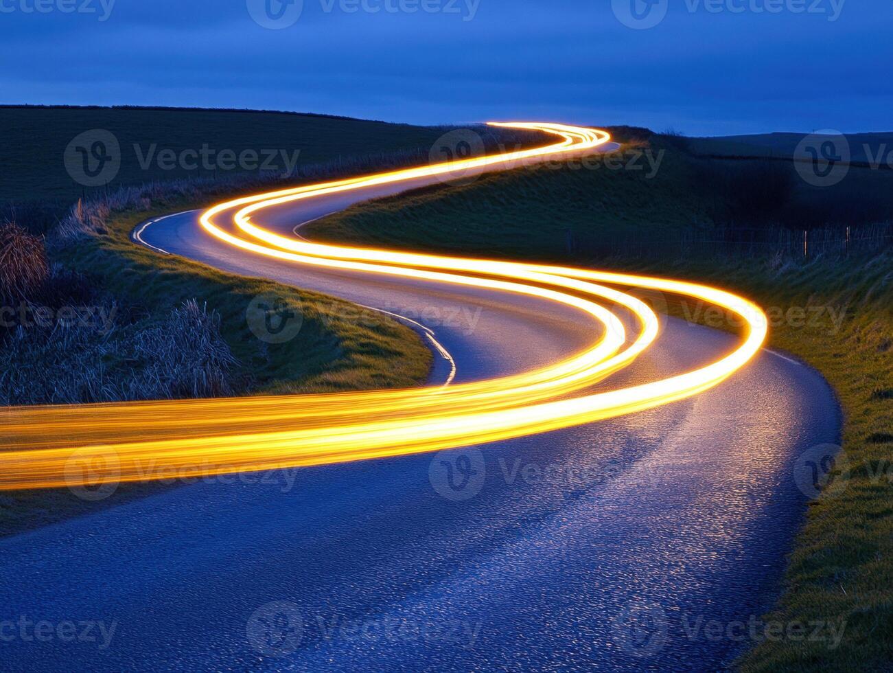 Curving country road illuminated by vehicle lights photo