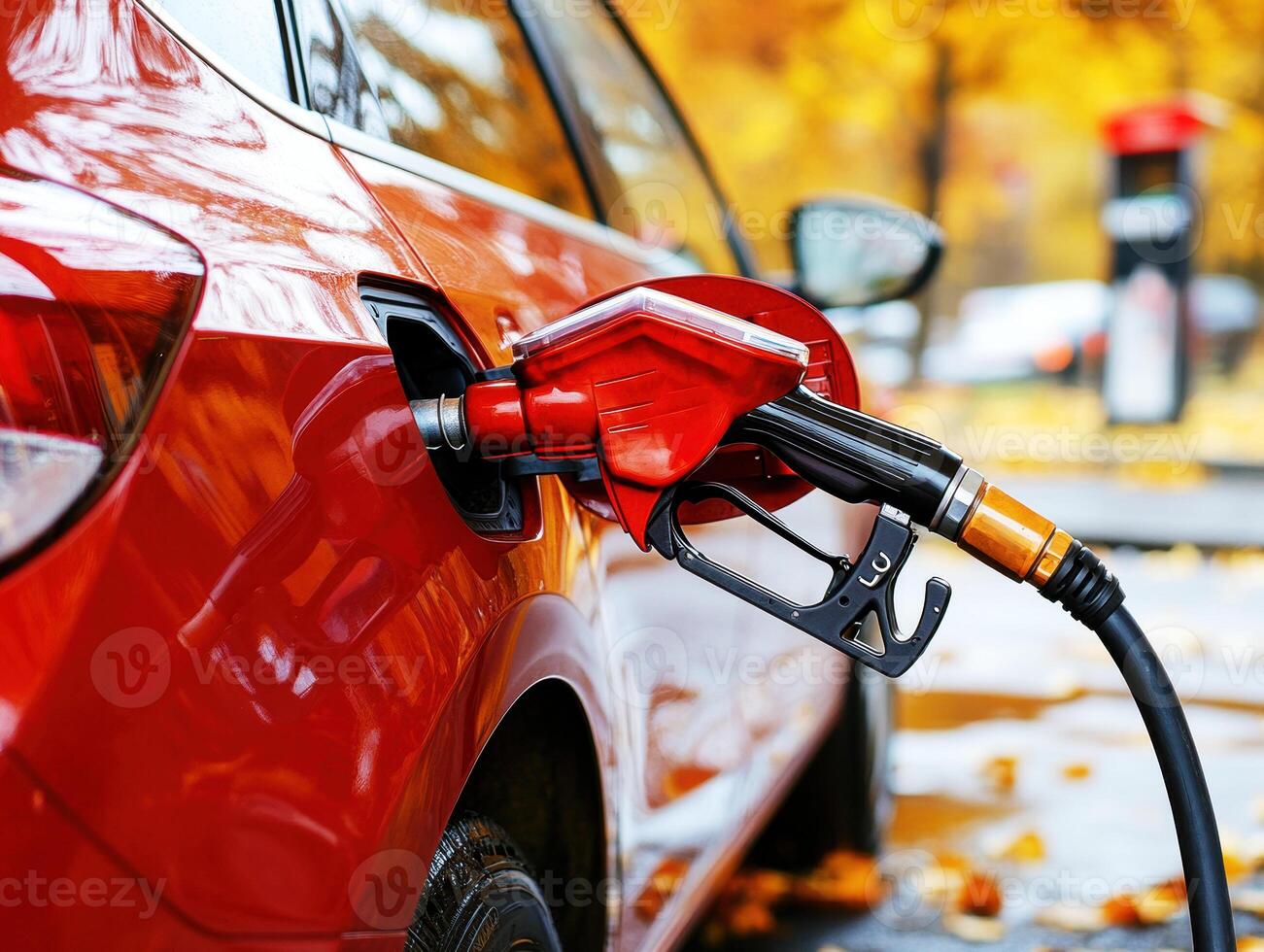 Car being refueled at a gas station during autumn photo