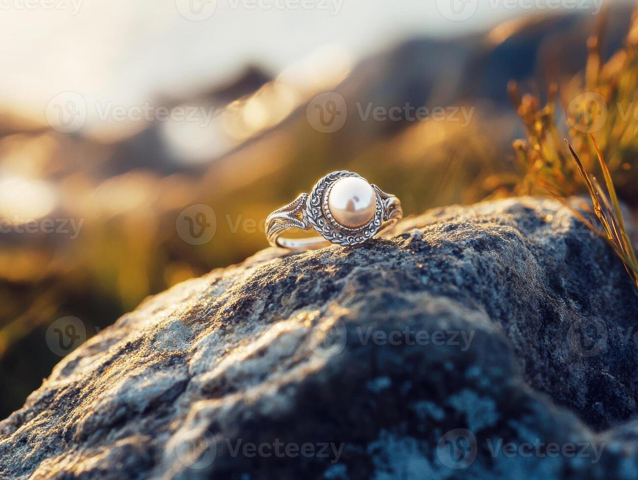 Elegant pearl ring resting on a rock by the water's edge photo