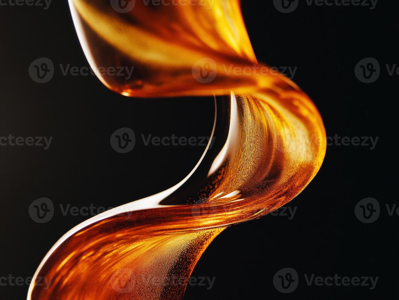 Golden syrup flows in elegant curves against a dark backdrop photo