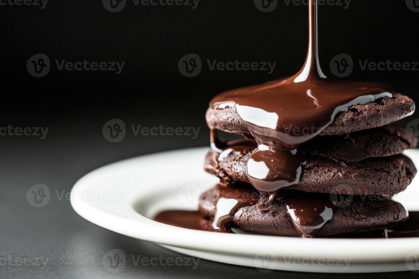 Decadent chocolate cookies stacked with rich sauce drizzling down photo