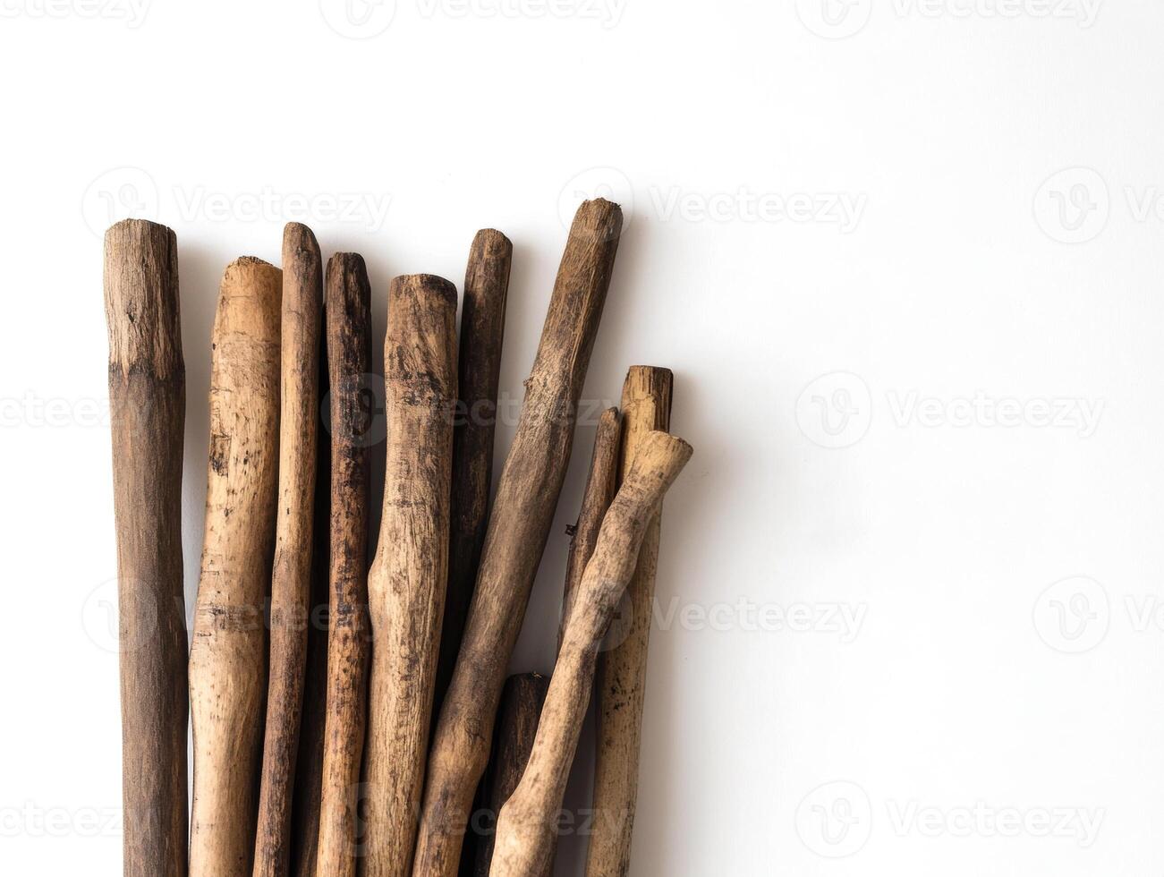 Collection of natural wooden sticks arranged on a white surface photo